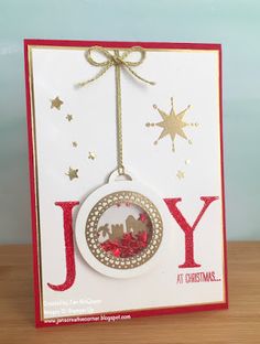 a christmas ornament hanging from a card with the word joy on it's side