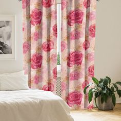 a bed sitting next to a window covered in pink flowers