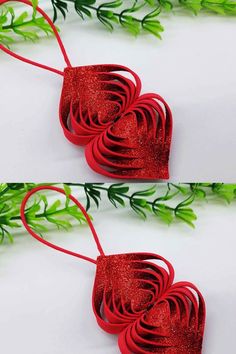 three red paper hearts hanging from green stems