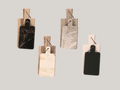 four tags with black and white marble on them hanging from clothes pins in the shape of rectangles