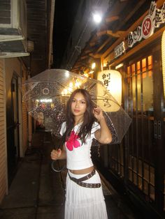 a woman holding an umbrella standing in front of a building