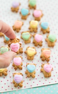 someone is holding up some heart shaped cookies on a sheet of paper with hearts in the shape of teddy bears