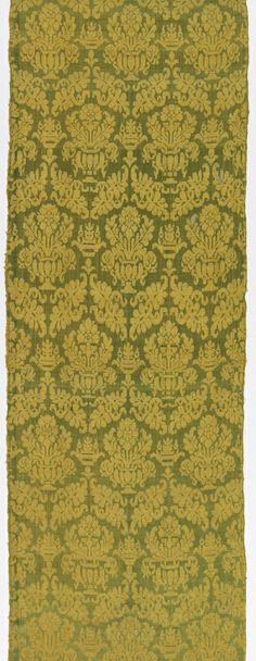 a green and yellow rug with an intricate design on it's side, in front of a white background