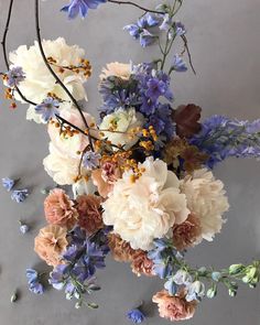 a bunch of flowers that are sitting on a table with blue and white flowers in it