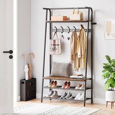 a coat rack with shoes and purses on it next to a potted plant