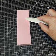 a person is using a sharp knife to cut out the edge of a piece of paper