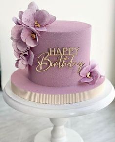 a purple birthday cake with flowers on top