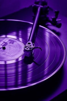 an old record player's turntable in purple light