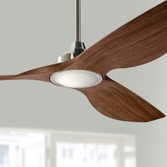 a ceiling fan with wooden blades in a room