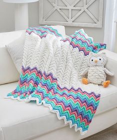 a crocheted blanket sitting on top of a white couch