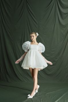 a woman in a white dress is posing for the camera