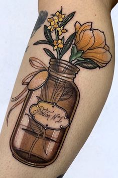 a woman's leg with a jar full of flowers on it and the word love in