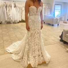 a woman standing in front of a wedding dress