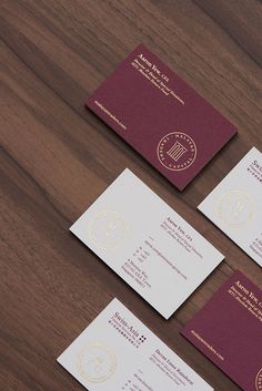 three red and white business cards sitting on top of a wooden table