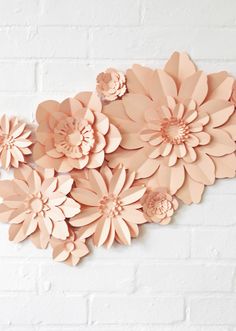 pink paper flowers on a white brick wall