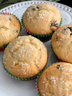 some muffins are sitting on a plate with white sprinkles and the words dried cherry muffins above them