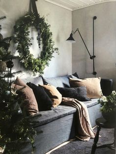 a living room filled with lots of furniture and christmas tree branches hanging from the wall