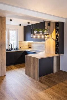 a kitchen with wooden floors and black cabinets