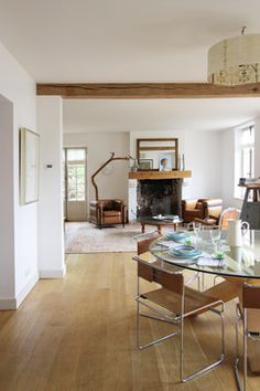 a dining room table and chairs in front of a fireplace