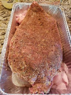 a piece of meat sitting on top of a pan covered in ice cream and seasoning