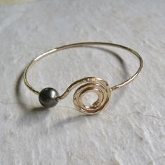 "Gold Spiral Bangle~ Beautiful gold spiral bangle, custom made for you, hammered and polished for that extra sparkle! The Spiral is a sacred symbol that represents the journey and change of life as it unfolds; taking a labyrinth-like passage that leads to Source. The spiral symbol can represent the consciousness of nature beginning from its center expanding outwardly. *Chose from 14 gauge or thicker 12 gauge from the drop down menu, also you can add a Tahitian pearl or white freshwater pearl. ** Gold Spiral Wire Wrapped Bracelets, Elegant Wire Wrapped Spiral Bracelets, Elegant Spiral Wire Wrapped Bracelets, Elegant Spiral Wire Wrapped Bracelet, Gold Spiral Bracelet As Gift, Gold Spiral Bracelet For Gift, Change Of Life, Surfer Girl Gifts, Spiral Symbol