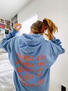 a woman in a blue hoodie with writing on it