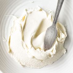 a white plate topped with whipped cream and a spoon