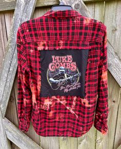 This is a one of a kind LUKE COMBS plaid flannel shirt.  This size LARGE flannel shirt has two pockets on the front, buttons up and is long sleeve. On the back of the shirt is a Luke Combs concert tee that has been sewn into the back of the shirt. The trim around the tee is frayed. This shirt has been bleached which gives it an overall distressed vintage style look.  All my shirts are ONE OF A KIND. They are all upcycled by being previously owned so there will be signs of wear and tear. This is what make each shirt unique in its own way and for sure makes them the most comfortable.  *NOTE: If your going to wear this as a oversized jacket  I recommend that you buy a size bigger than you would normally wear. Here are some popular ways to wear these shirts.  All my flannels are men's  flannel Distressed Long Sleeve Shirt For Fall, Distressed Button-up Shirt For Fall, Plaid Flannel Grunge Shirt, Plaid Flannel Shirt In Grunge Style, Plaid Grunge Flannel Shirt, Grunge Plaid Flannel Shirt, Plaid Flannel Shirt For Fall, Grunge Style, Grunge Cotton Flannel Shirt For Fall, Plaid Flannel Grunge Top