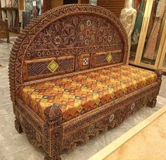 an intricately carved wooden bench in a shop