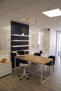 an office with eyeglasses on the wall and wooden table in front of it