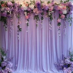 the backdrop is covered with purple flowers and greenery for an elegant wedding or special event