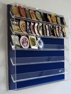 a wall mounted shelf with several different types of buttons and magnets attached to it