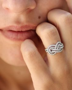 a close up of a person with a ring on their finger and her hand near her face