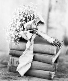 a stack of books with a bouquet of flowers sitting on top of one another next to each other