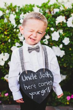 a little boy holding a heart shaped sign