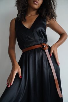 Add a touch of sophistication to your outfit with this exquisite leather knot belt. This black dress belt features a minimalist style that effortlessly elevates any look. Perfect for the fashion-forward woman, this tie belt is a versatile and chic accessory that can be styled in multiple ways. Make a statement with this elegant black women's belt that adds a modern twist to any ensemble. belt will undoubtedly expand the possibilities of your wardrobe, adding elegance and style to each of your ou Knot Belt Outfit, Chic Solid Dresses With Belt, Chic Solid Color Dress With Belt, Chic Leather Party Belts, Leather Belted Dress For Date Night, Chic Brown Belt For Party, Chic Evening Belt, Chic Brown Party Belt, Chic Belts For Spring Evening