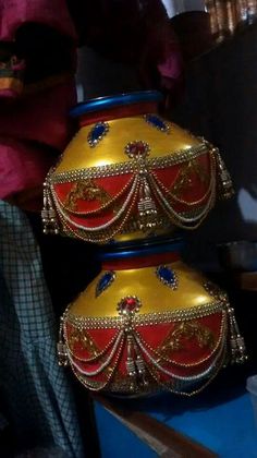 two colorful vases sitting on top of a blue table next to a stuffed animal