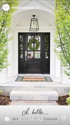 a black front door with the words hello written on it and an image of trees