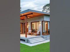 a modern house with an open porch and covered patio area in the evening time,