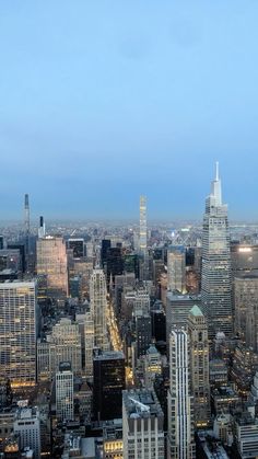 an aerial view of the city skyline at night with skyscrapers and other tall buildings