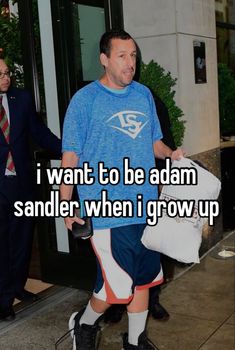 a man in blue shirt and shorts walking down street with his hand on his hip