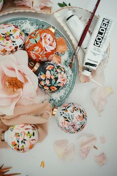 an assortment of decorated eggs and flowers on a plate next to a tube of toothpaste