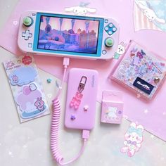 an image of a cell phone and accessories on the table with hello kitty stickers