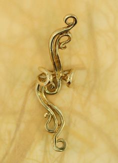 This French Twist Ear Cuff is cast in bronze and is elegant and fluid and can be worn on either the left or the right ear (diamond not included). Our ear cuffs require no piercings. Starting near the top of the ear, slide the ear cuff down along the edge of the ear's cartilage. You may gently open or close the opening of the ear cuff to accommodate the thickness of your ear. Our bronze ear cuffs are antiqued lightly, and bronze will tarnish, or patina over time. To maintain the golden color, cle Elegant Gold Brass Ear Cuff, Elegant Gold Metal Ear Climbers, Gold Metal Ear Cuff For Wedding, Gold Brass Ear Cuff For Parties, Elegant Brass Ear Climbers As A Gift, Elegant Pierced Brass Ear Cuff, Elegant Silver Brass Ear Cuff, Gold Wire Wrapped Ear Cuff As Gift, Gold Metal Wire Wrapped Ear Cuff