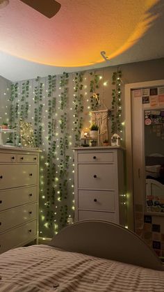 a bedroom decorated with green vines and lights