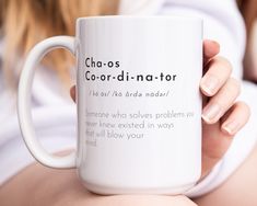 a woman holding a white coffee mug with the words chaos, co - or - nadator on it