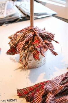 a basket filled with cloth sitting on top of a table next to a wooden stick