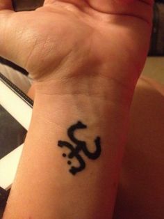 a person with a tattoo on their wrist that has an omen symbol on it