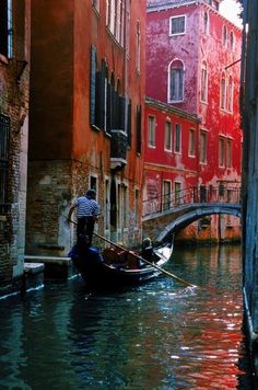 a gondola in the middle of a narrow canal with buildings on both sides