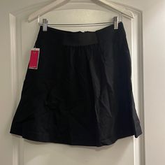 Zip In Back Black A-line Mini Skirt For Work, Black Stretch A-line Mini Skirt, Elegant Black A-line Skort, Black Knee-length Skort For Spring, Black A-line Mini Skirt For Workwear, A-line Black Mini Skirt For Work, Black A-line Pleated Skort, Black Relaxed Knee-length Skort, Black Flared Mini Skirt For Workwear